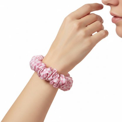 Pink and white patterned scrunchie on a beige background