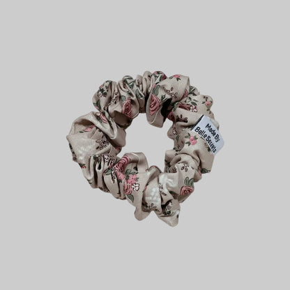 Floral scrunchie with a label on a beige fabric background