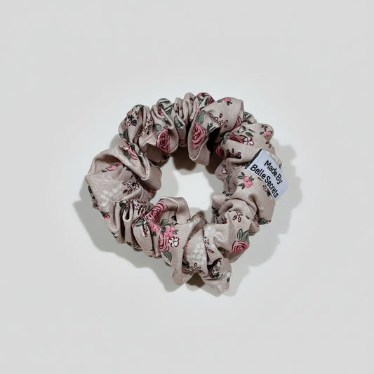 Floral scrunchie with a label on a beige fabric background
